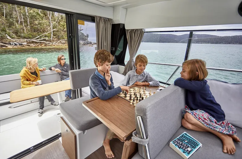 Slide: The Image of Family enjoying chess on Jeanneau NC 1095 Fly boat, 2020 model, with scenic water view. - 9