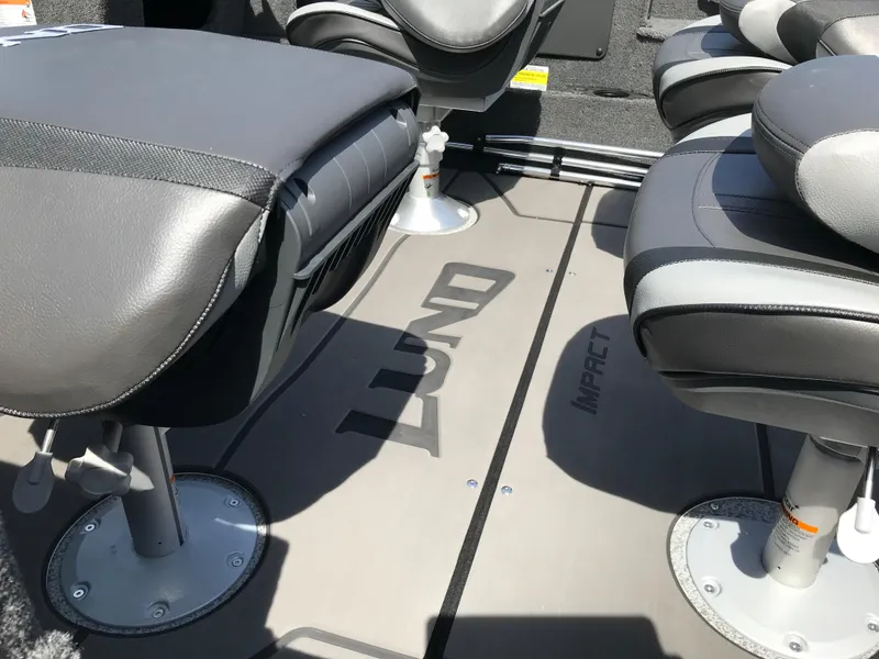 Slide: The Image of 2025 Lund 1875 Impact XS Sport boat interior with cushioned seats and branded flooring. - 14