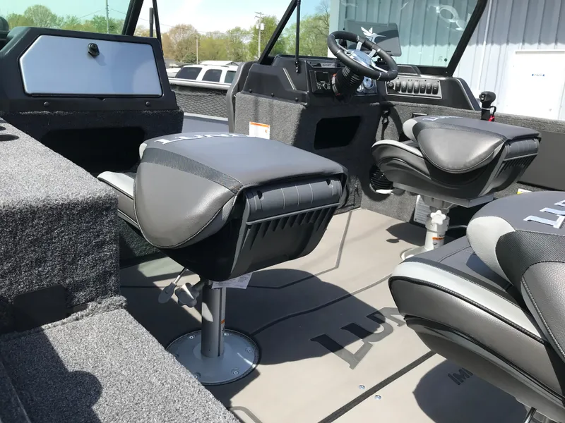 Slide: The Image of 2025 Lund 1875 Impact XS Sport boat interior with modern seating and steering console. - 18