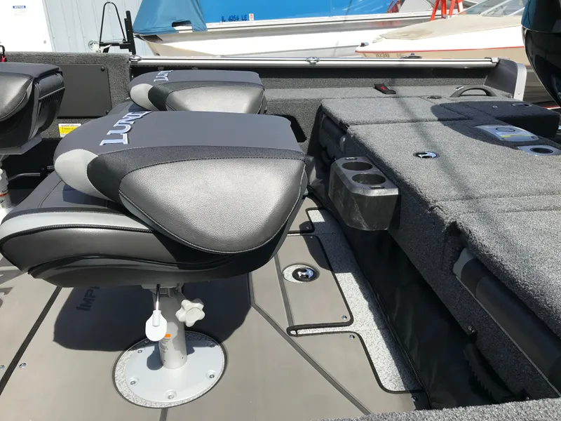 Slide: The Image of 2025 Lund 1875 Impact XS Sport boat interior with cushioned seating and storage compartments. - 19