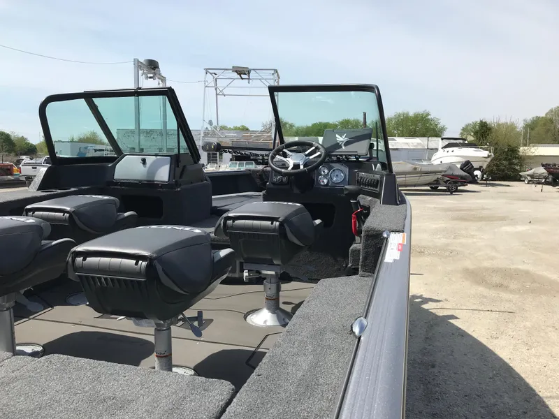 Slide: The Image of 2025 Lund 1875 Impact XS Sport boat interior with seating and steering console. - 21