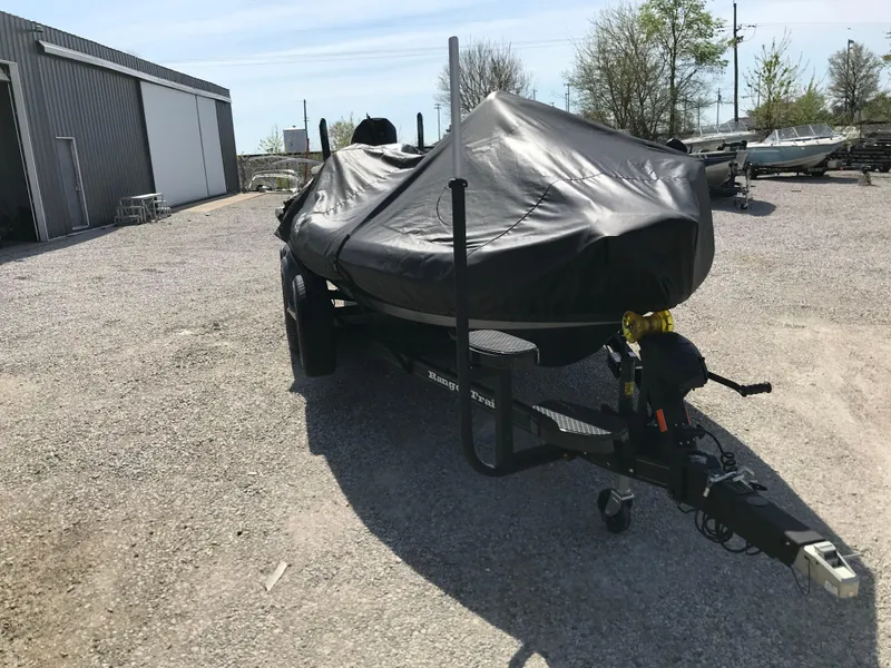 Slide: The Image of 2025 Lund 1875 Impact XS Sport boat covered on trailer in outdoor storage area. - 5