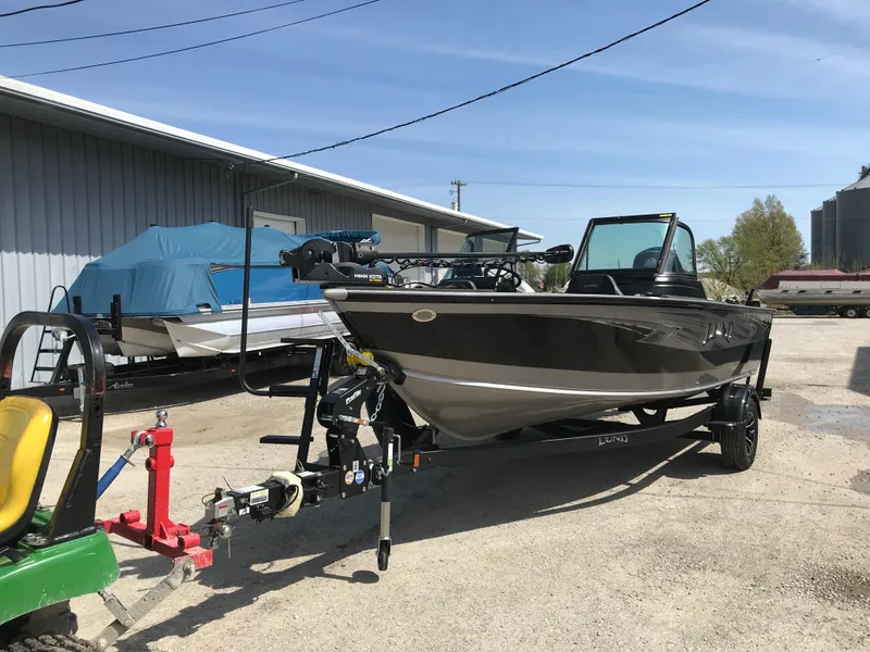Slide: The Image of 2025 Lund 1875 Impact XS Sport boat on trailer, parked outdoors. - 8