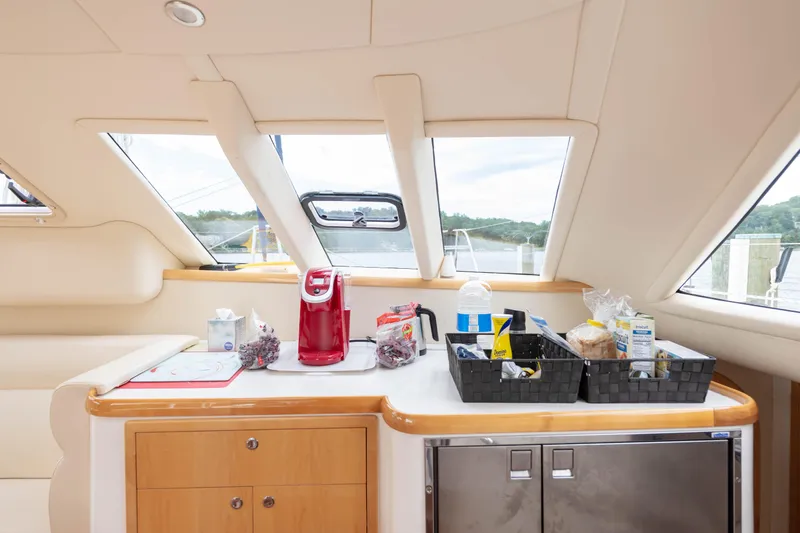 Slide: The Image of Luxurious yacht interior with kitchen amenities, featuring a red coffee maker and organized baskets. - 29