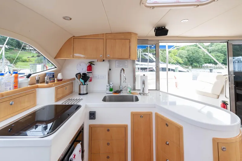 Slide: The Image of Modern kitchen interior on a 2017 Balance 451 yacht, featuring sleek countertops and wooden cabinetry. - 30