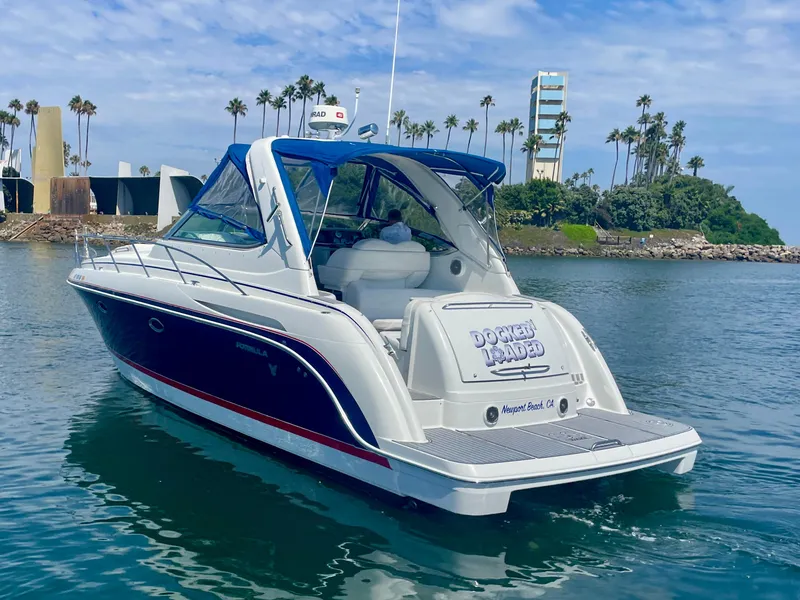 Slide: The Image of 2004 Formula 37 PC yacht cruising in a scenic harbor with palm trees. - 10