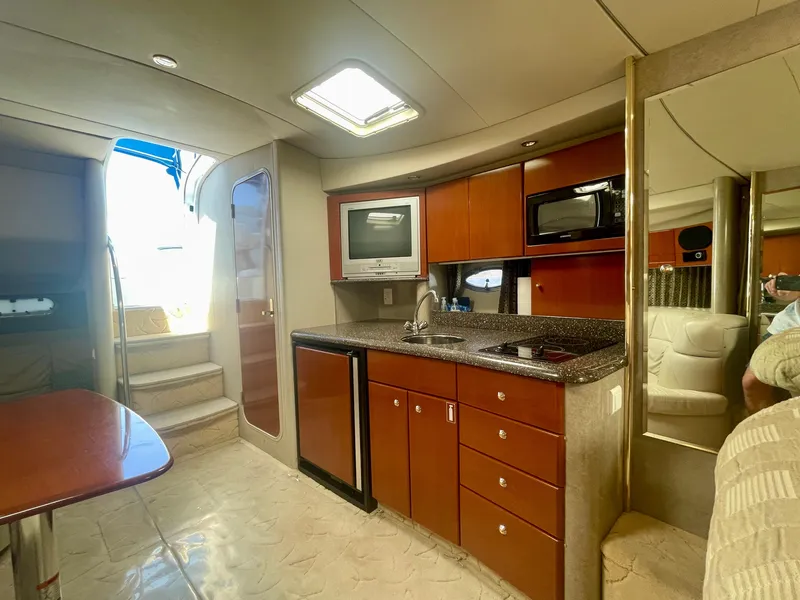 Slide: The Image of 2004 Formula 37 PC yacht interior with kitchenette, featuring wood cabinets and modern appliances. - 14