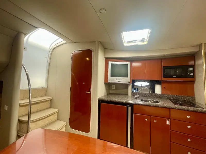 Slide: The Image of 2004 Formula 37 PC yacht interior with kitchenette, stairs, and wooden cabinetry. - 17