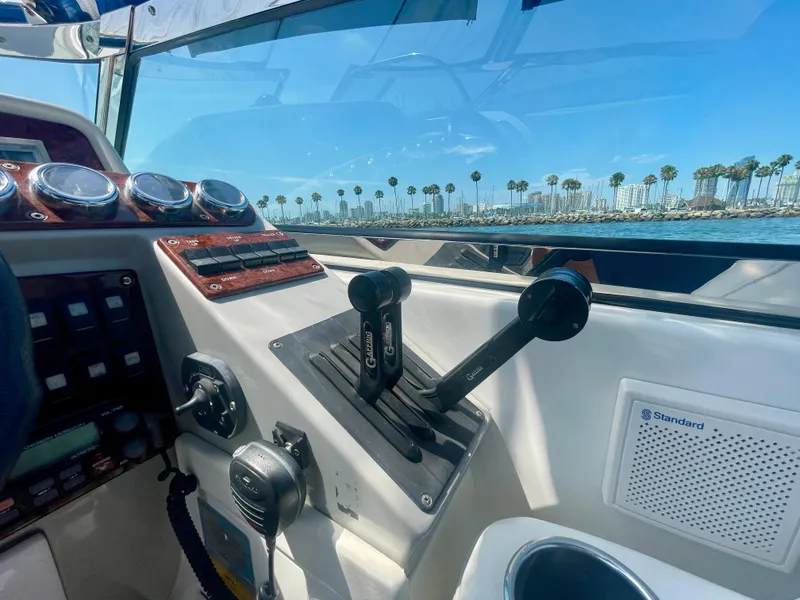 Slide: The Image of 2004 Formula 37 PC boat cockpit with controls, gauges, and ocean view. - 42