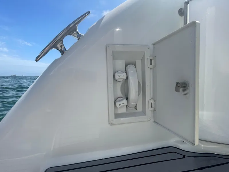 Slide: The Image of 2004 Formula 37 PC boat water hookup compartment with open door, ocean background. - 46
