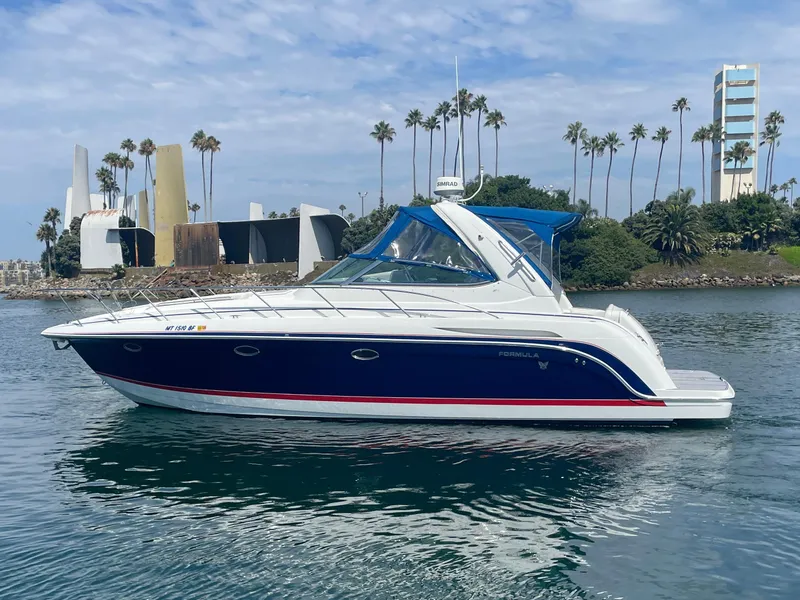 Slide: The Image of 2004 Formula 37 PC yacht on calm water with modern architecture and palm trees in background. - 5
