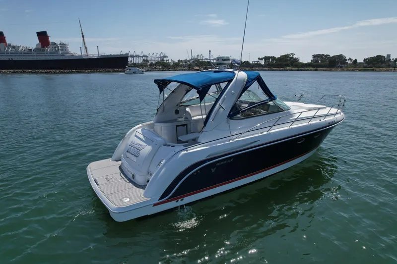 Slide: The Image of 2004 Formula 37 PC yacht on calm water with blue canopy and sleek design. - 7