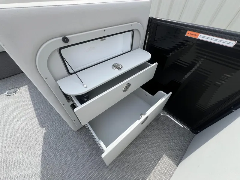 Slide: The Image of Interior storage compartments of 2022 Crest Classic Fish 200 boat, featuring open drawers. - 14