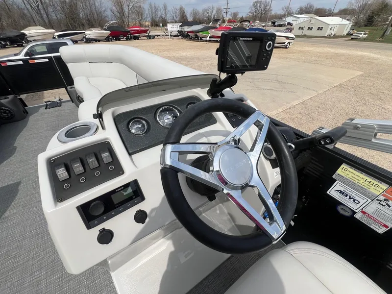 Slide: The Image of 2022 Crest Classic Fish 200 boat dashboard with steering wheel and control panel. - 16