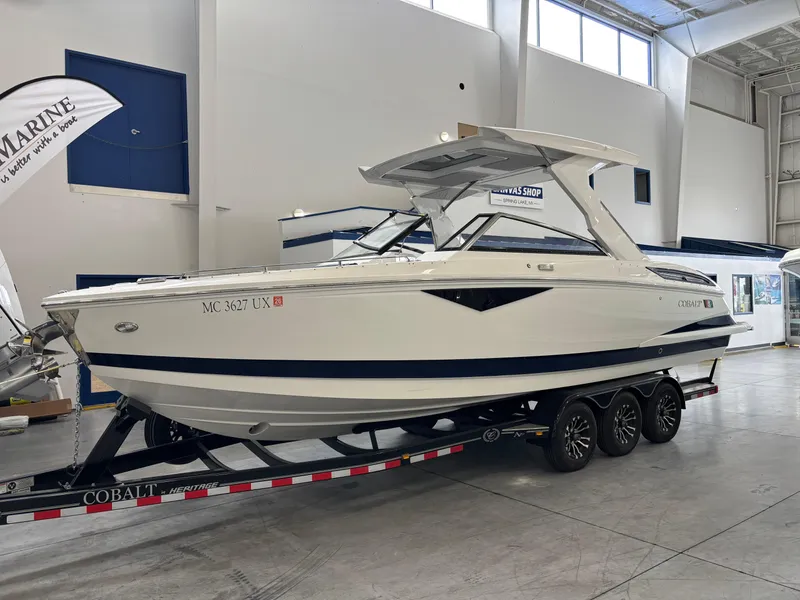 Slide: The Image of 2022 Cobalt A29 boat on trailer in showroom, white with blue accents. - 0