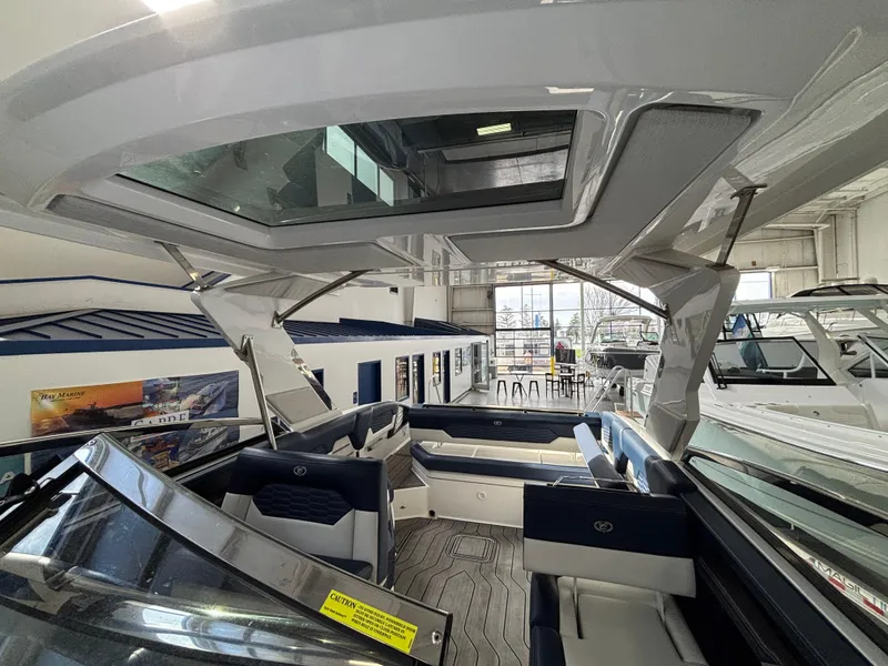 Slide: The Image of 2022 Cobalt A29 boat interior with sleek design and spacious seating in a showroom. - 9