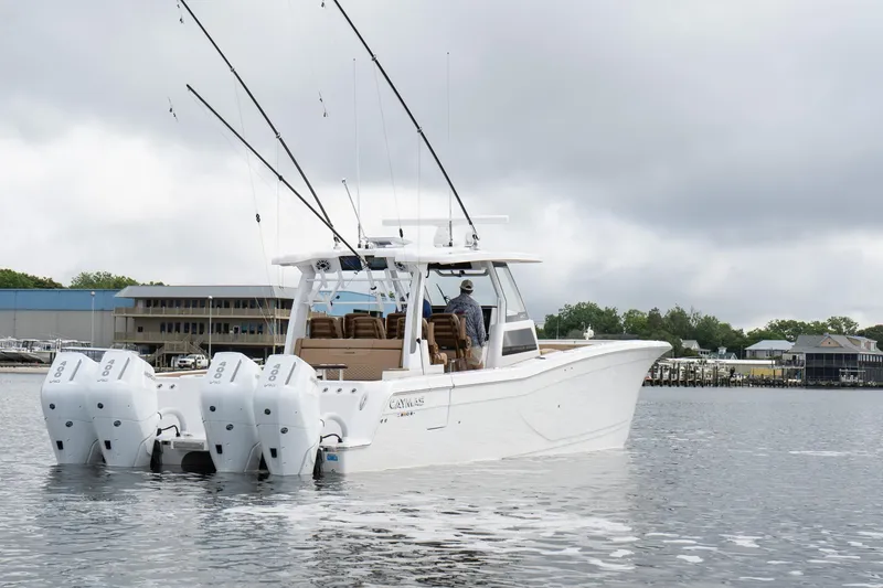 Slide: The Image of 2025 Caymas 44 CT boat with multiple outboard engines on a calm waterway. - 10