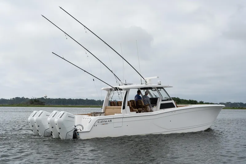 Slide: The Image of 2025 Caymas 44 CT boat with multiple fishing rods on a calm water body. - 12