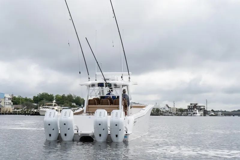 Slide: The Image of 2025 Caymas 44 CT boat with four engines on a cloudy day, cruising on calm water. - 13