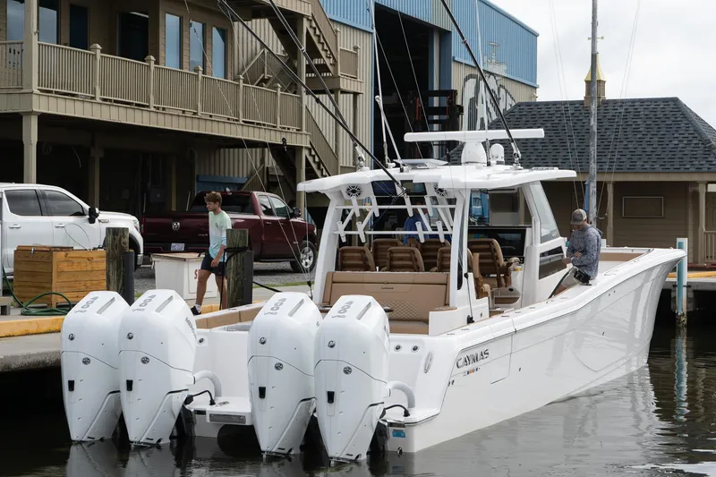 Slide: The Image of 2025 Caymas 44 CT boat docked with four powerful outboard engines. - 15