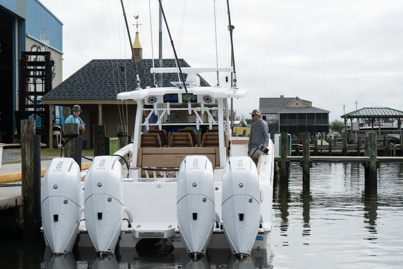 Slide: The Image of 2025 Caymas 44 CT boat docked with four powerful outboard engines. - 16