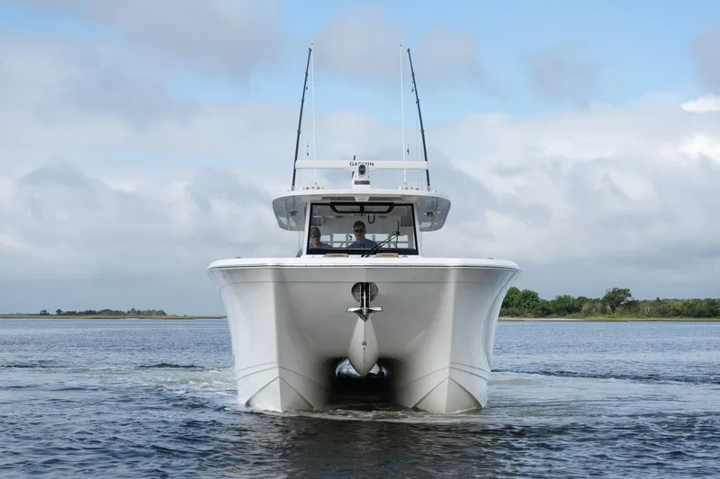 Slide: The Image of 2025 Caymas 44 CT catamaran cruising on open water under a cloudy sky. - 2
