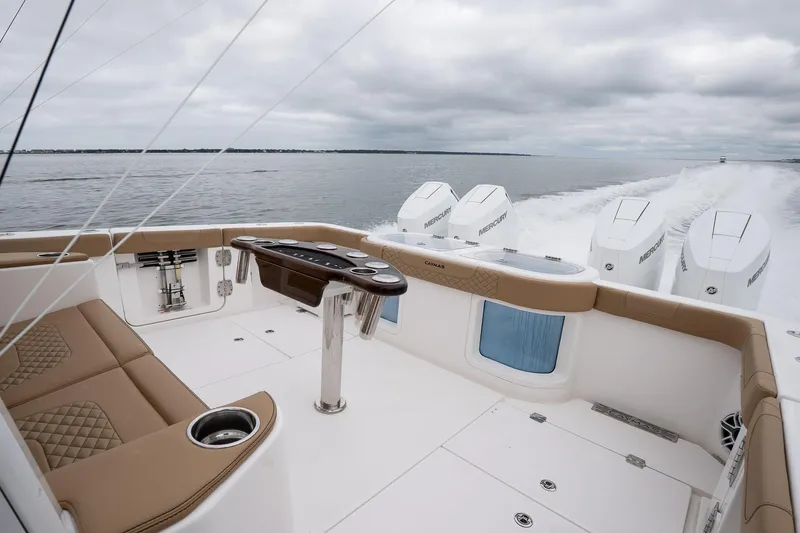 Slide: The Image of 2025 Caymas 44 CT boat interior with luxurious seating and powerful outboard engines on open water. - 25