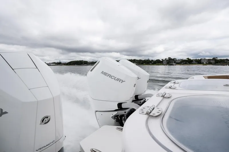 Slide: The Image of 2025 Caymas 44 CT boat with Mercury engines cruising on a cloudy day. - 28