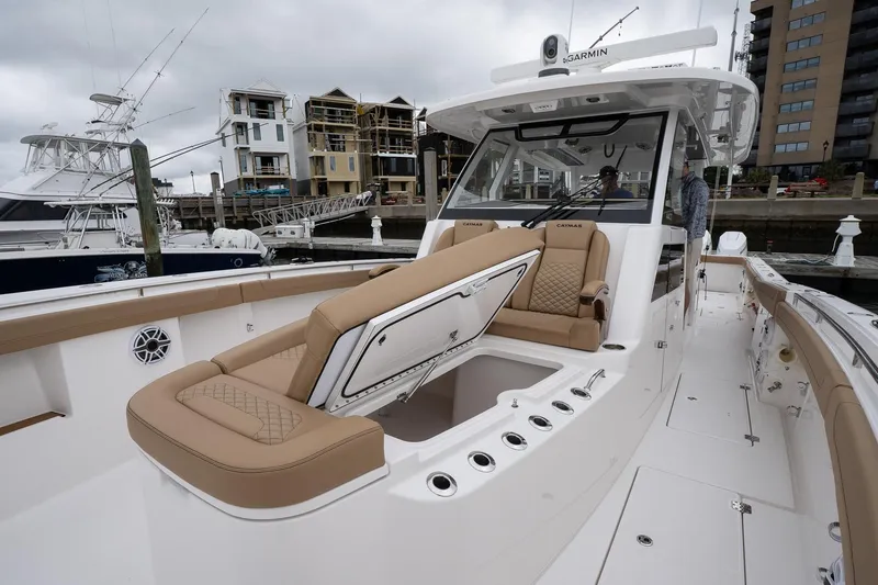 Slide: The Image of 2025 Caymas 44 CT boat with luxurious seating, docked in a marina. - 33