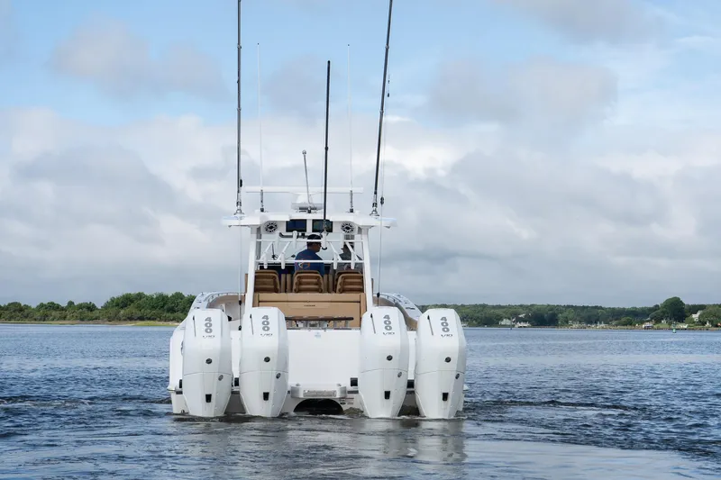 Slide: The Image of 2025 Caymas 44 CT boat with multiple outboard engines on a calm waterway. - 5