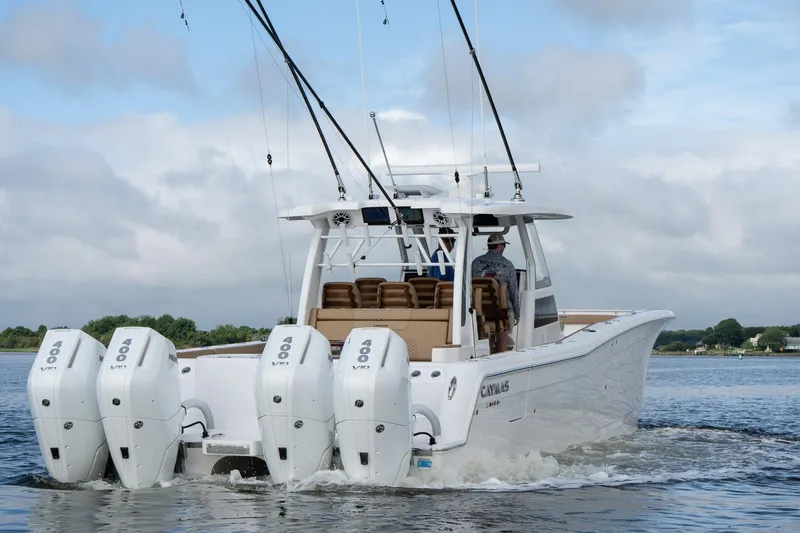 Slide: The Image of 2025 Caymas 44 CT boat with four powerful engines cruising on water. - 6