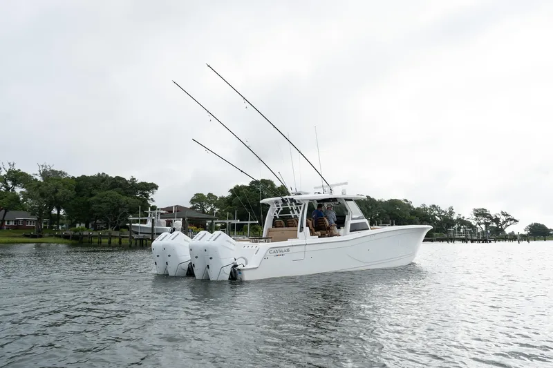 Slide: The Image of 2025 Caymas 44 CT boat with triple engines on a calm lake. - 8