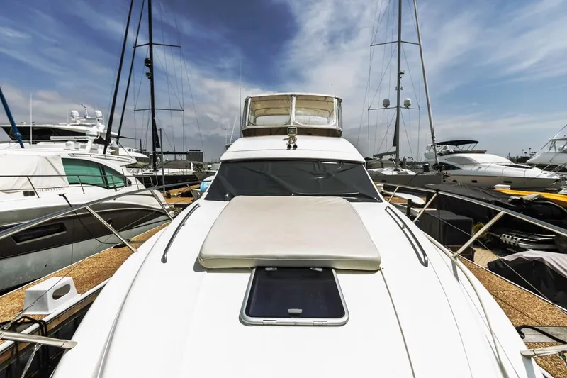 Slide: The Image of 2000 Viking 46 Flybridge Sport Cruiser docked at marina, surrounded by other yachts. - 10