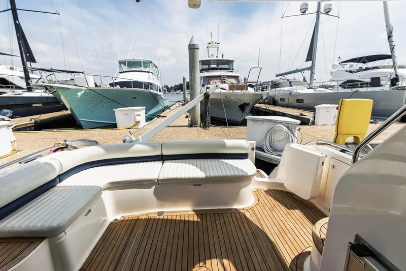 Slide: The Image of 2000 Viking 46 Flybridge Sport Cruiser docked, featuring spacious deck and luxurious seating. - 11