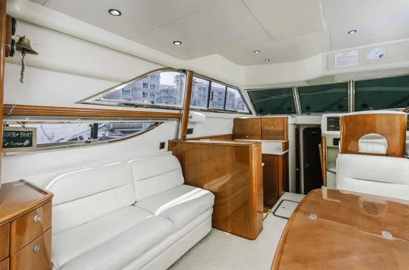 Slide: The Image of Interior of 2000 Viking 46 Flybridge Sport Cruiser with white seating and wooden accents. - 23