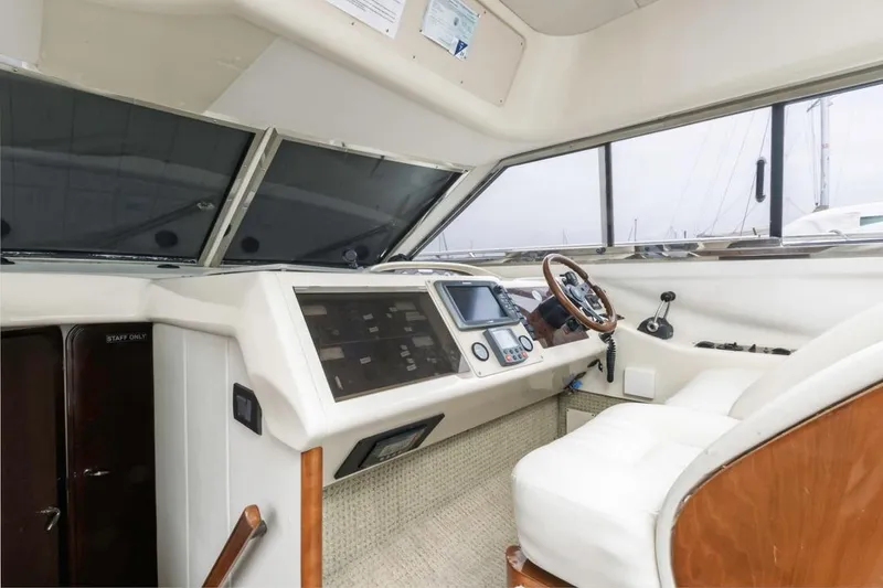 Slide: The Image of Helm of 2000 Viking 46 Flybridge Sport Cruiser with modern controls and wooden steering wheel. - 24