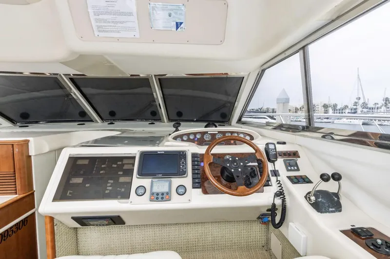 Slide: The Image of Helm of 2000 Viking 46 Flybridge Sport Cruiser with navigation equipment and wooden steering wheel. - 25