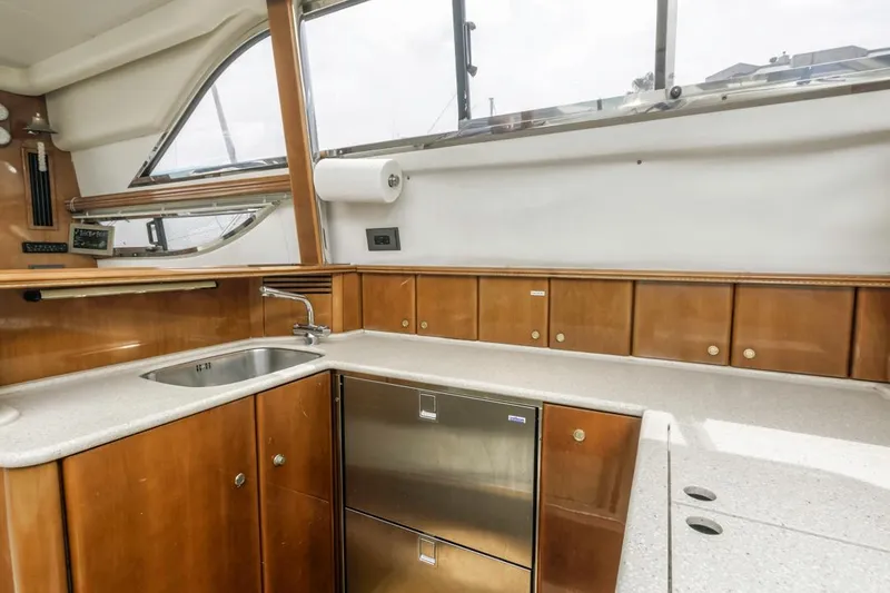Slide: The Image of Interior of 2000 Viking 46 Flybridge Sport Cruiser kitchen with wood cabinets and stainless steel appliances. - 26
