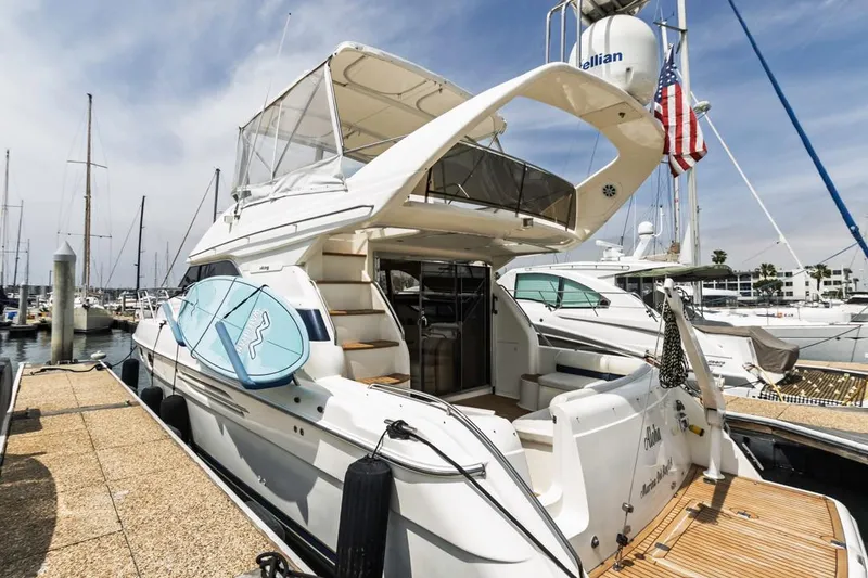 Slide: The Image of 2000 Viking 46 Flybridge Sport Cruiser docked at marina, featuring sleek design and spacious deck. - 3