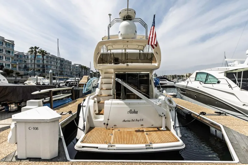 Slide: The Image of 2000 Viking 46 Flybridge Sport Cruiser docked at marina, rear view with American flag. - 5