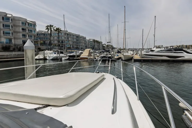 Slide: The Image of Viking 46 Flybridge Sport Cruiser 2000 docked in a marina with modern buildings. - 8