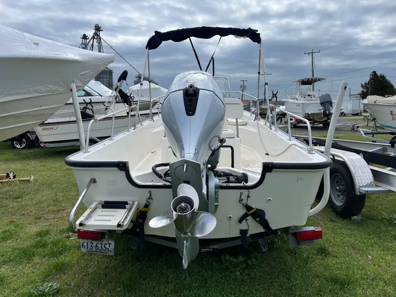 Slide: The Image of 2003 Boston Whaler 170 Montauk boat, rear view, on grass with other boats nearby. - 6