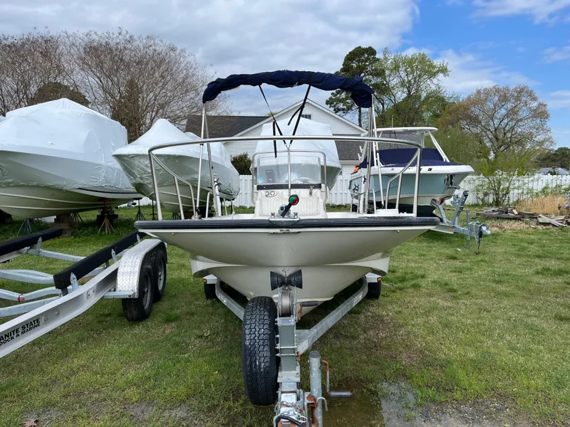 Slide: The Image of 2003 Boston Whaler 170 Montauk boat on trailer, parked outdoors with other boats. - 9