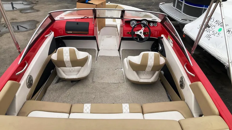 Slide: The Image of 2016 Glastron GT 205 boat interior with red and beige seating, dashboard, and steering wheel. - 3