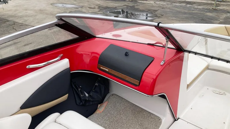 Slide: The Image of 2016 Glastron GT 205 boat interior with red dashboard and white seating. - 6