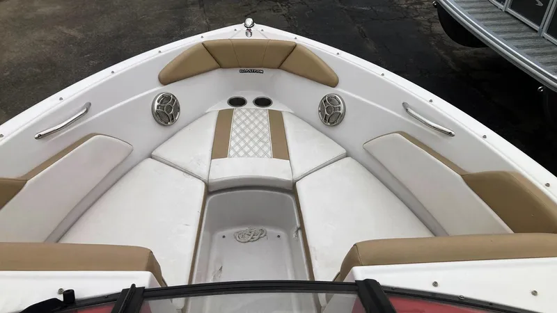Slide: The Image of 2016 Glastron GT 205 boat interior with beige and white seating, featuring built-in speakers. - 7
