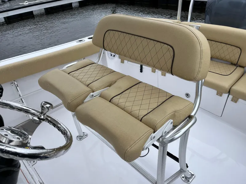 Slide: The Image of 2022 Sportsman Heritage 231 Center Console boat with tan cushioned seating and steering wheel. - 14