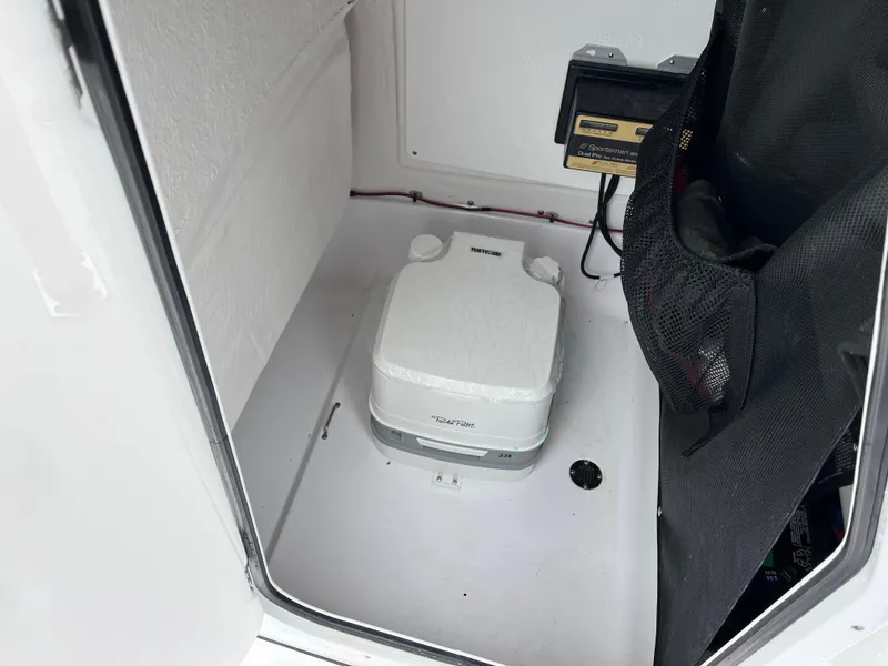 Slide: The Image of 2022 Sportsman Heritage 231 Center Console boat interior with portable toilet. - 6