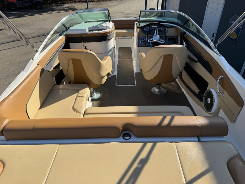 Slide: The Image of 2015 Sea Ray 220 Sundeck interior with tan seating and modern dashboard. - 10