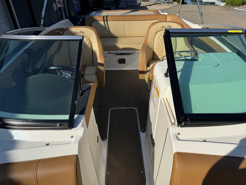 Slide: The Image of 2015 Sea Ray 220 Sundeck interior with tan seating and dual windshields. - 13